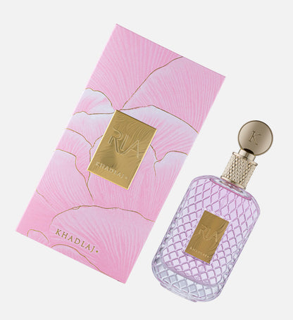 Khadlaj Ria Eau de Parfum bottle and pink gift box laid side by side at an angle, showing the gold RIA Khadlaj label on both